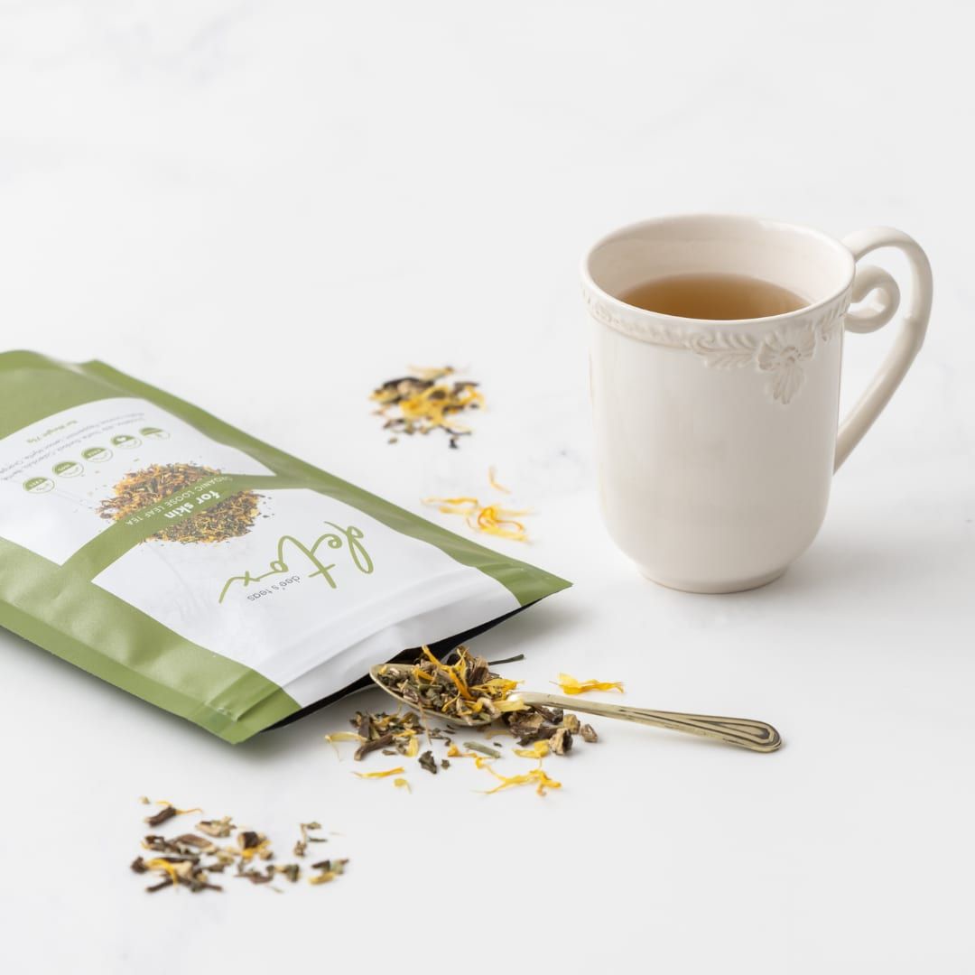 A pack of Dee’s Teas Detox Tea beside a white mug of tea